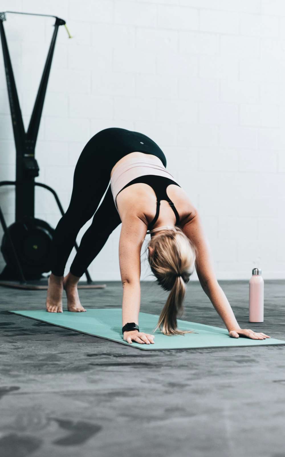 Femme en appui sur les mains et les pieds pendant un exercice dans une salle de sport.