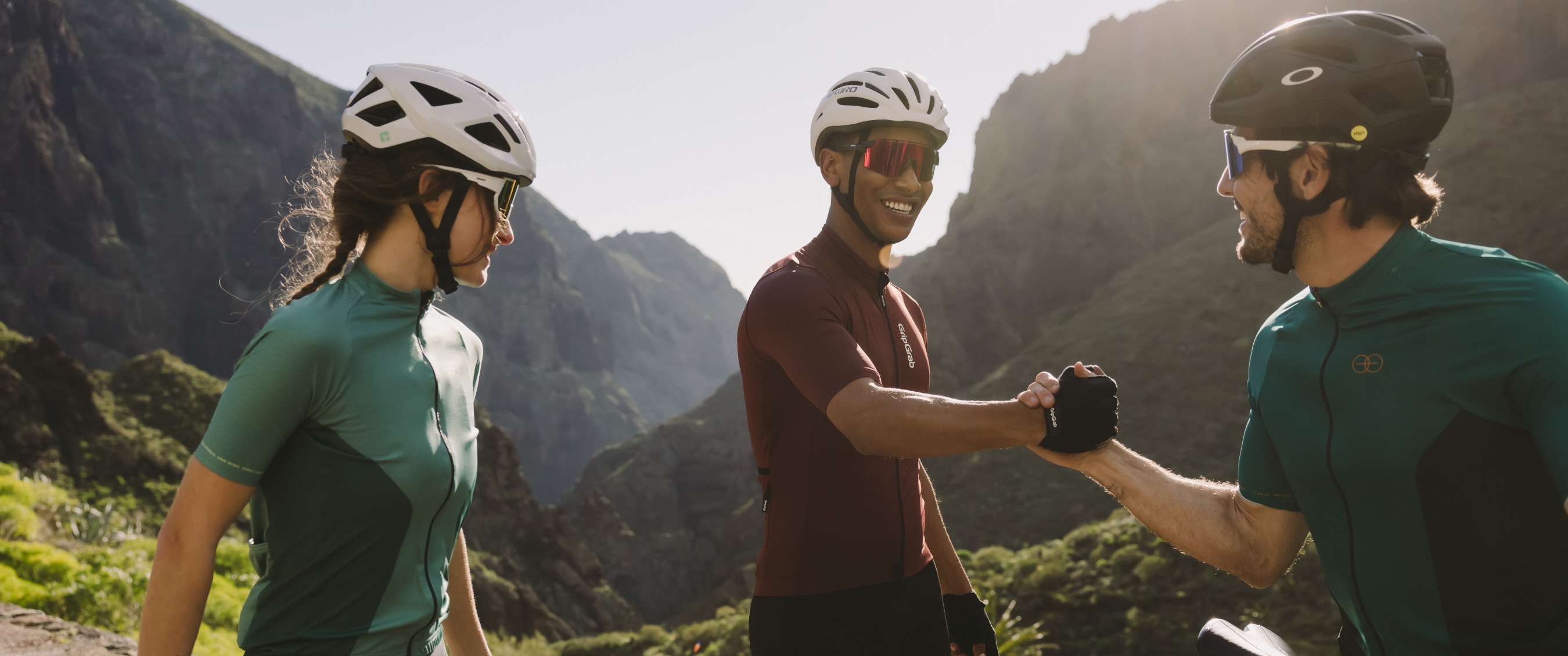 Cyclistes avec lunettes de sport et casques ensemble sur une route de montagne ensoleillée
