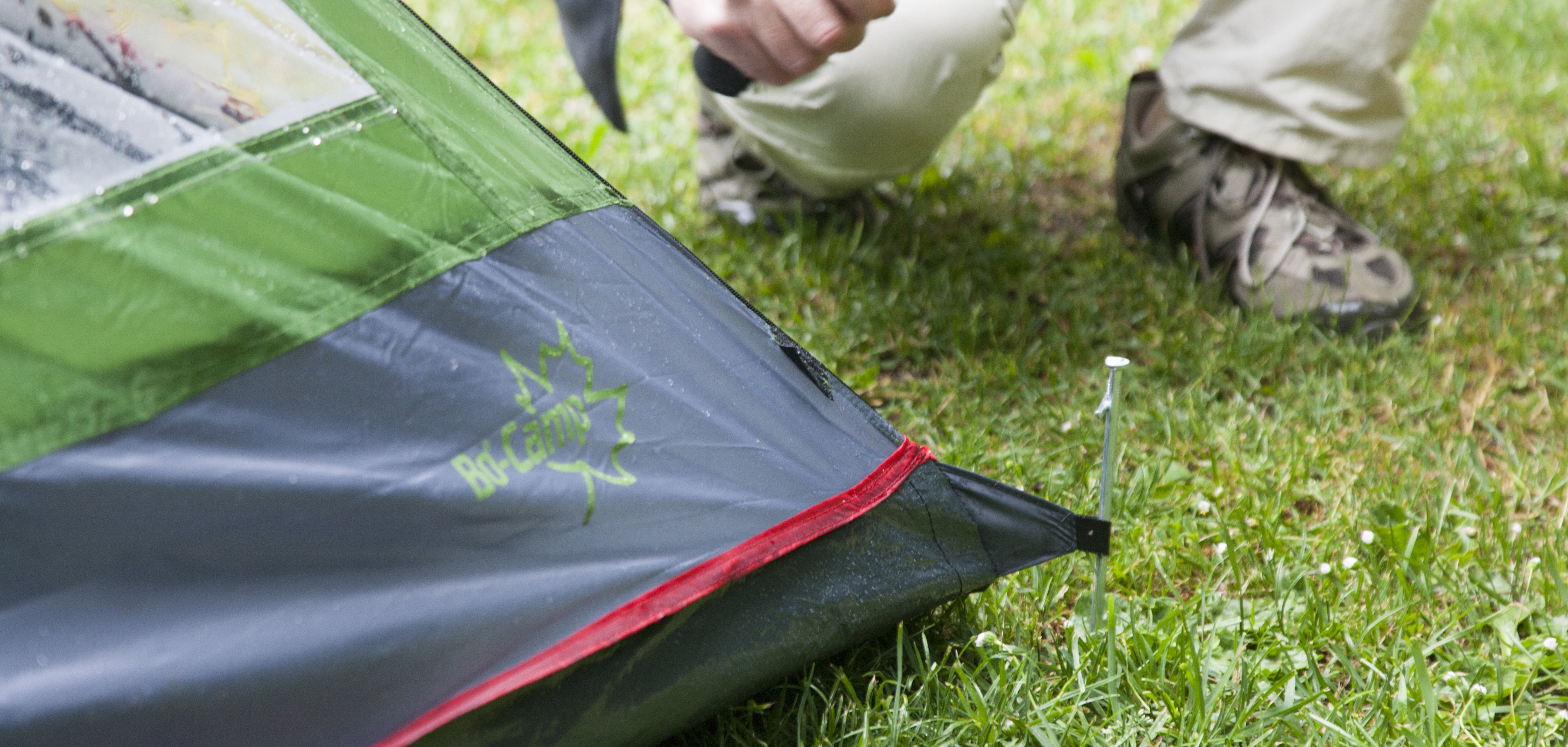 Man maakt scheerlijnen van zijn tent goed vast