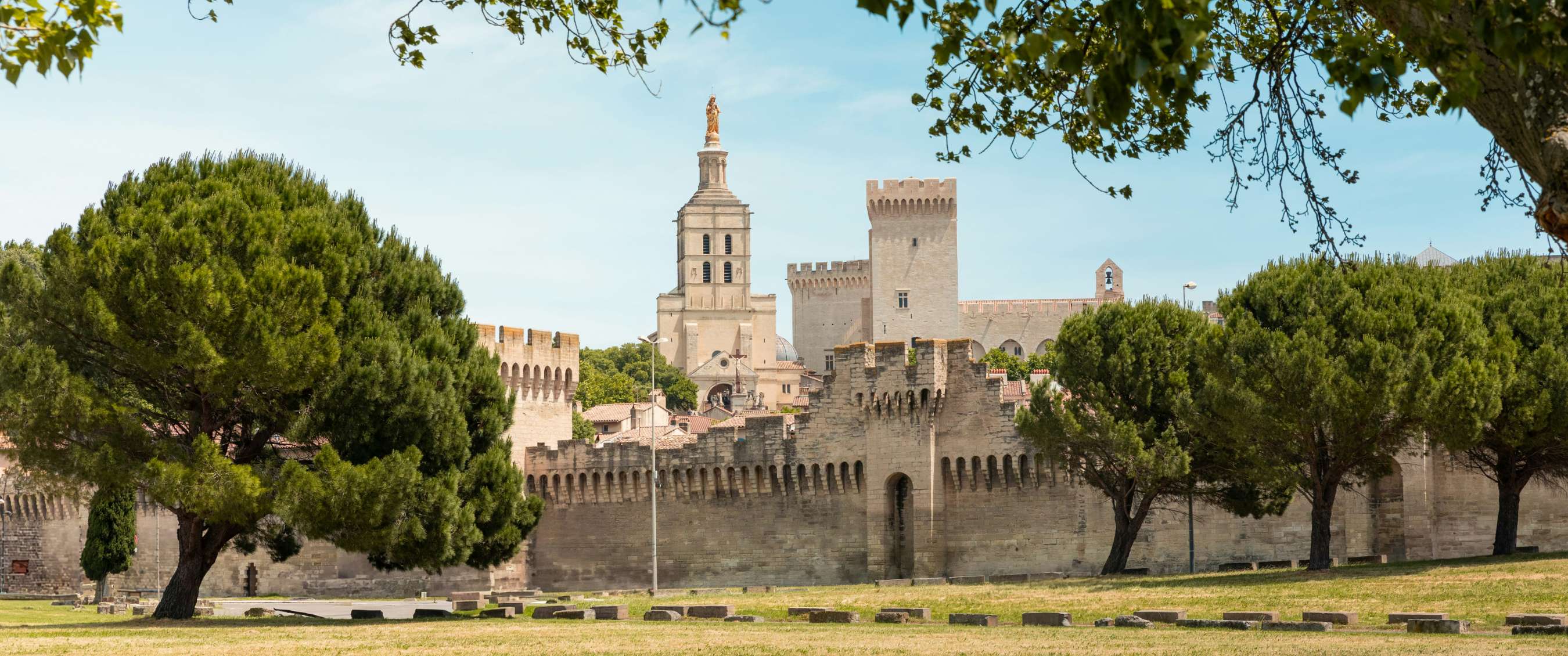 Rempart historique avec tours et arbres sous un ciel clair.