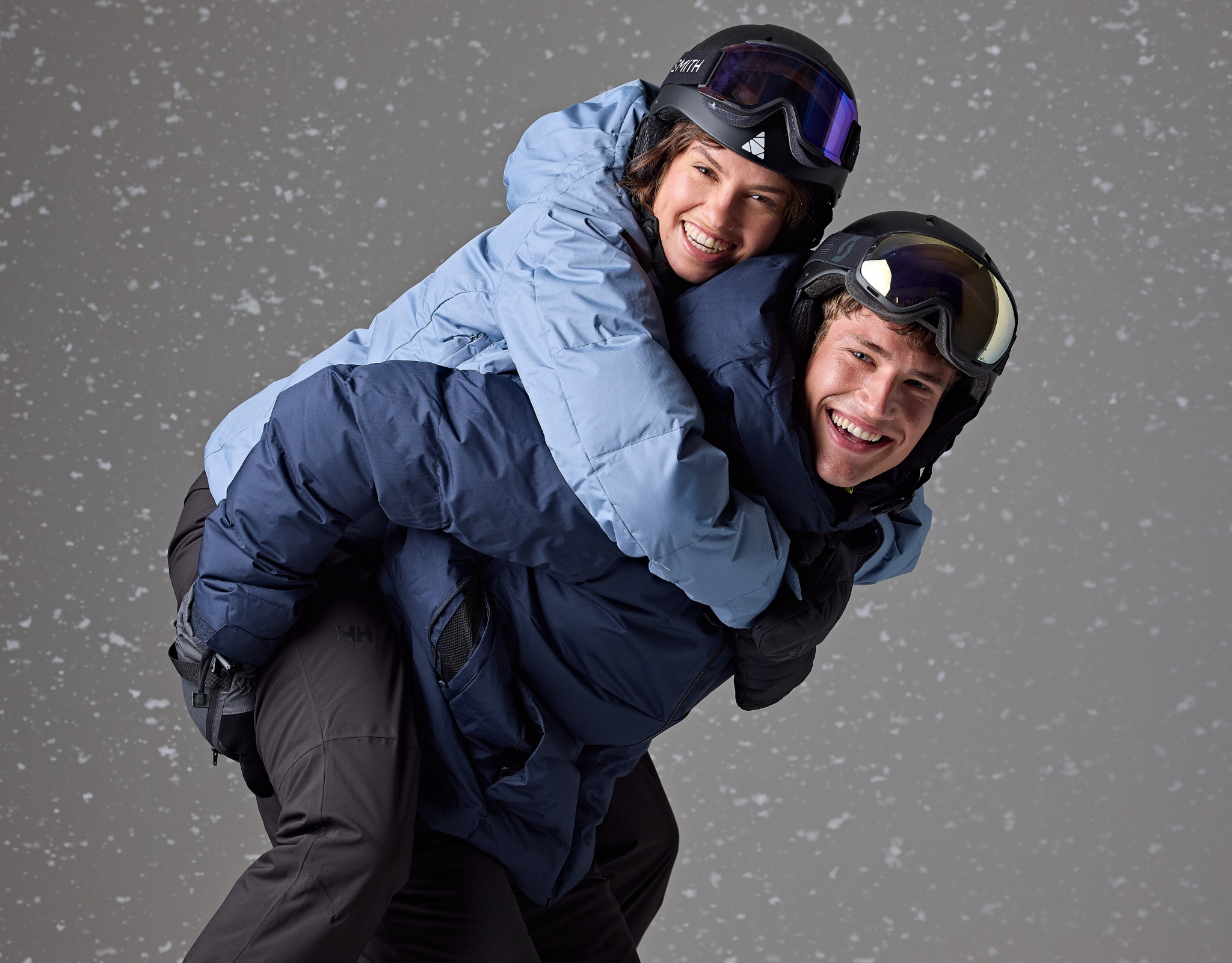 Deux personnes souriantes, l’une portant l’autre sur le dos.